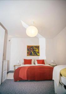 a bedroom with a large bed with a red blanket at Ferienwohnung "Zum Köpfel"- Wiesenthal in der Rhön in Wiesenthal