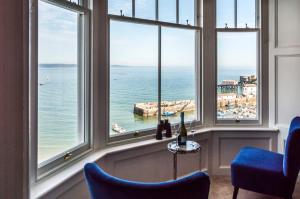 um quarto com janelas com vista para o oceano em Fisherman's Catch - Two Bedroom Luxury Apartment - Tenby em Tenby