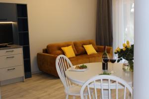 a living room with a table and a couch at Apartament Orange Sun nr°7 in Pobierowo