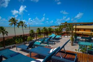 una terraza con sillas azules y la playa en Hotel do Mar Cabo Branco en João Pessoa