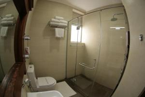 a bathroom with a toilet and a glass shower at The Royal Mall in Kandy