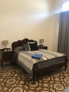 Villa Mosta في موستا: غرفة نوم بسرير كبير مع مواقف ليلتين
