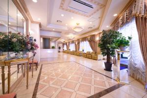 a lobby of a hospital with chairs and plants at Hotel Capital in Yamagata in Yamagata