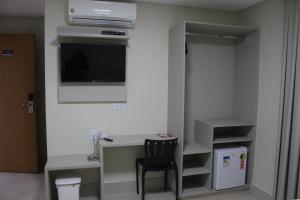 a small kitchen with a refrigerator and a microwave at Sudoeste Hotel in Goiânia