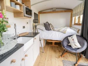 a small kitchen with a bed in a tiny house at Betws View, Shepherd Hut in Betws-y-coed