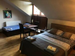 1 dormitorio con 1 cama y 1 mesa con comedor en Apartamenty Maria en Żywiec