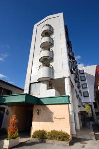 - un bâtiment avec des balcons ronds sur le côté dans l'établissement Hotel Capital in Yamagata, à Yamagata