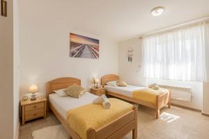 een slaapkamer met twee bedden en een raam bij Villa Loza - Resort Moja stina in Seoca