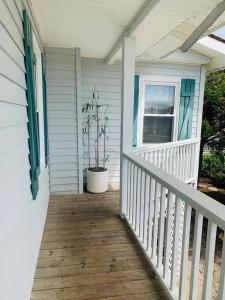 un porche de una casa con una maceta en ella en Wayne's World, en Holden Beach