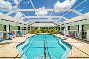 a swimming pool with a patio area with chairs and umbrellas at Ivey House Everglades Adventures Hotel in Everglades City