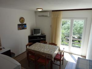uma sala de jantar com uma mesa e cadeiras e uma janela em Three bedroom apartment & studio - Apartments Ždrijac em Nin