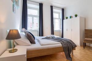 1 dormitorio con cama, lámpara y ventanas en Yeshello Elegant Apartment near Central Vienna en Viena
