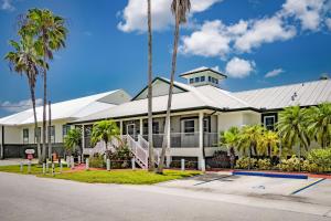 ein großes weißes Gebäude mit Palmen davor in der Unterkunft Ivey House Everglades Adventures Hotel in Everglades City