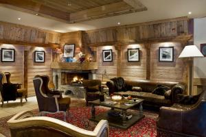 a living room with leather furniture and a fireplace at Hotel Beauregard in La Clusaz