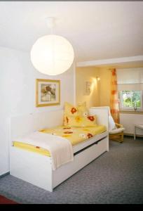 a bedroom with a large white bed with yellow sheets at Ferienwohnung "Zum Köpfel"- Wiesenthal in der Rhön in Wiesenthal
