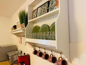 a kitchen with a rack of cups on the wall at TM Aparts in Dortmund +33 photos
