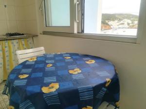 ポンツァにあるRosa - Immobilevanteの窓付きのキッチン(テーブル上の青い掛け布団)