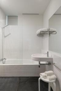 a white bathroom with a sink and a tub at Quinta da Caída in Arcas