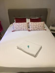 a white bed with pillows and a white towel on it at Château Gombert in Marseille