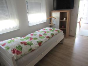 Un dormitorio con una cama con una manta floral. en Peter Lamster Top3, en Frauenkirchen