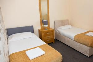 a small room with two beds and a mirror at Alexander Apartments Roker in Sunderland