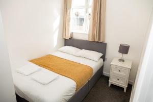 een kleine slaapkamer met een bed en een raam bij Alexander Apartments Roker in Sunderland