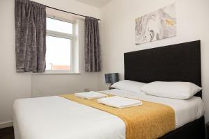 a bedroom with a bed with two towels on it at Alexander Apartments Roker in Sunderland