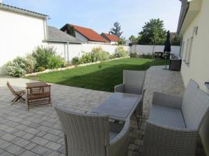 patio ze stołem, krzesłami i trawnikiem w obiekcie Peter Lamster Top3 w mieście Frauenkirchen