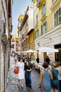 Un groupe de personnes marchant dans une rue avec des parapluies dans l'établissement Garibaldi Suites Piazza Di Spagna, à Rome