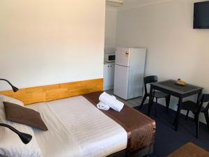 莫里莫里巴斯汽车旅馆的一间卧室，配有一张床、一张桌子和一台冰箱