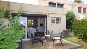 a patio with chairs and a table on a deck at Villa T6, 10 couchages, front de mer, piscine, Saint Pierre la Mer in Saint Pierre La Mer