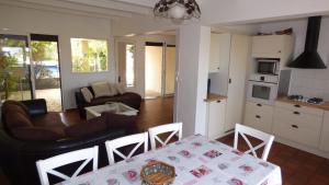 a kitchen and a living room with a table and chairs at Villa T6, 10 couchages, front de mer, piscine, Saint Pierre la Mer in Saint Pierre La Mer