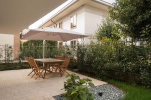 a table and chairs with an umbrella in a garden at Da Coco - Apartments in Padova