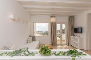 duży biały salon z dużym oknem w obiekcie Overview Mykonos Apartments w mieście Mykonos