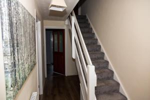 a hallway with stairs leading up to a door at Backworth - Alexander Apartments in Backworth