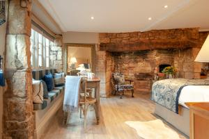 a bedroom with a bed and a stone wall at Woolmarket House in Chipping Campden