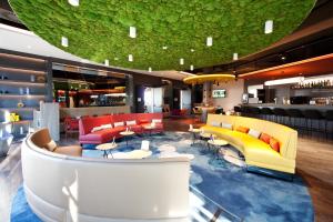 lobby z kolorowymi meblami i barem w obiekcie ibis Styles Parndorf Neusiedler See w mieście Parndorf