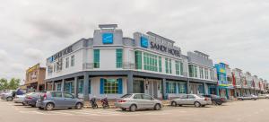 ein großes Gebäude mit Autos auf einem Parkplatz in der Unterkunft Sandy Hotel Malacca in Malakka