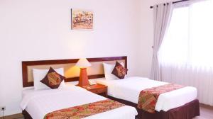 Rúm í herbergi á Griya Sentana Hotel