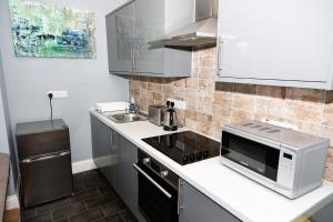 a small kitchen with a microwave and a sink at Tyne Apartments in Gateshead