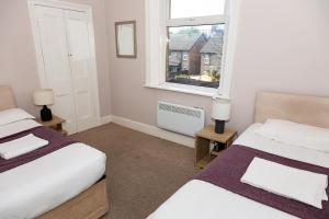 a bedroom with two beds and a window at Tyne Apartments in Gateshead