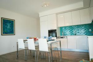 a kitchen with white cabinets and a table with white chairs at Marlin House IV in Ferrel