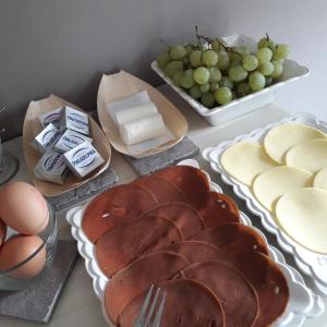 une table recouverte de assiettes de pain, de fromage et de raisins dans l'établissement Cascina Spazio Indaco, à Castagnole Monferrato