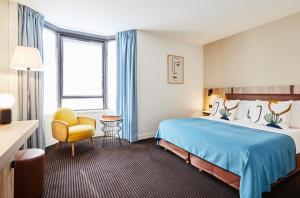een hotelkamer met een bed en een stoel bij Plaza Tour Eiffel in Parijs