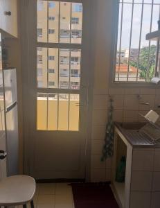 a kitchen with a door and two windows at Appartement sympathique Jules Ferry. in Dakar