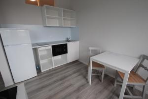 een kleine keuken met een witte tafel en een witte koelkast bij Schlafhaus Dünenweg 16 in Heringsdorf
