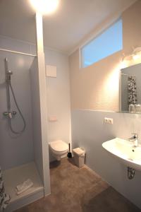 a bathroom with a sink and a shower and a toilet at Schlafhaus Dünenweg 16 in Heringsdorf