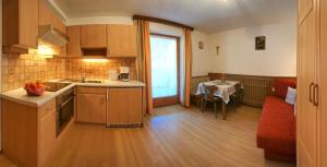 uma cozinha com um lavatório e uma mesa num quarto em Haus Hochzeigerblick em Wenns