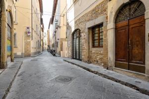 een lege straat in een steegje met een houten deur bij Palazzo Pitti Apartment with Terrace in Florence