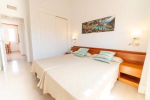 ein Schlafzimmer mit einem Bett mit zwei Kissen darauf in der Unterkunft Aparthotel Ciudad Laurel in Cala Millor